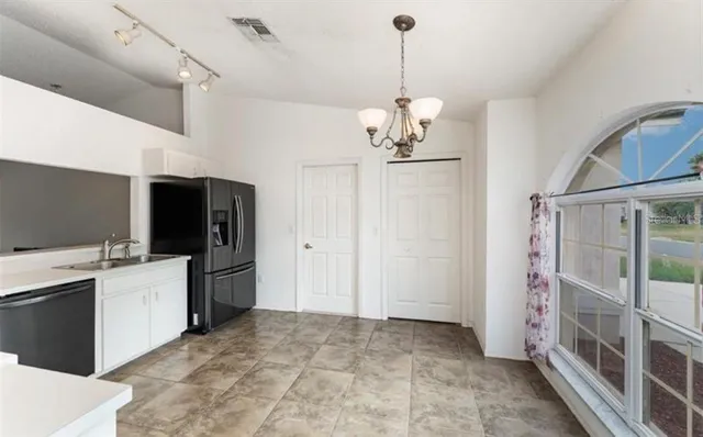 a view of a kitchen with a sink and refrigerator
