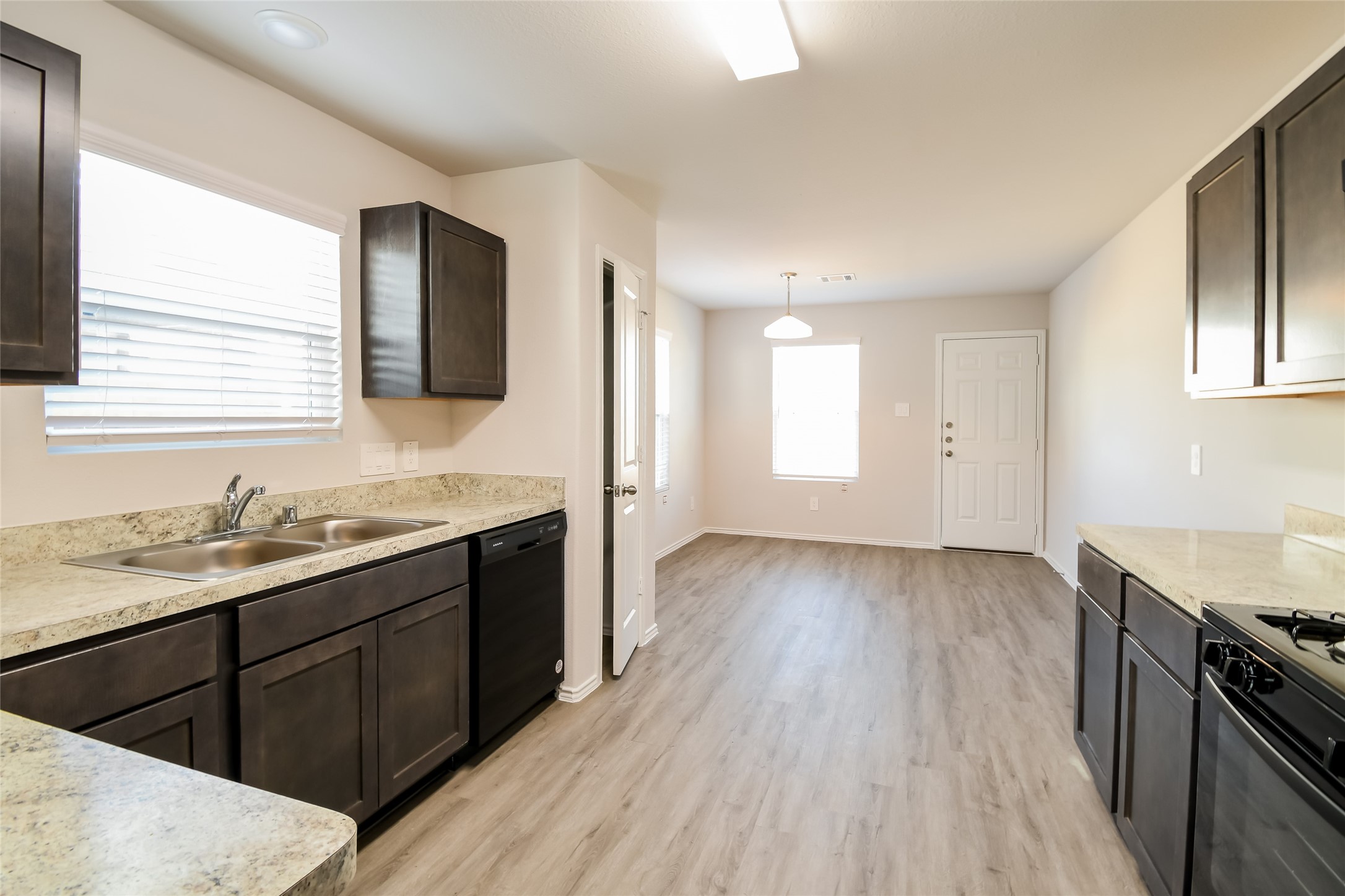 a kitchen with a sink and wooden floor