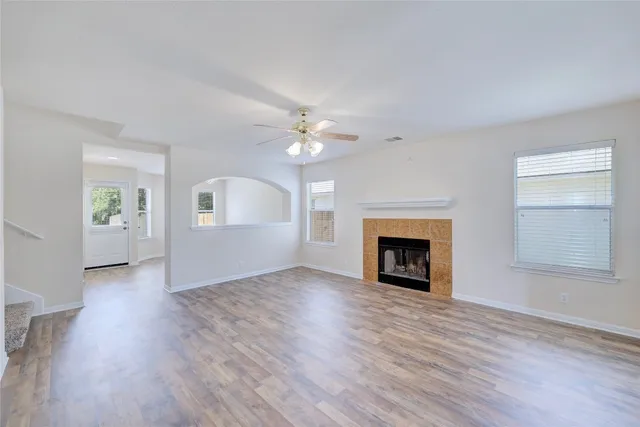a view of an empty room with a fireplace and a window