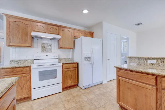 a kitchen with stainless steel appliances granite countertop a refrigerator stove and sink
