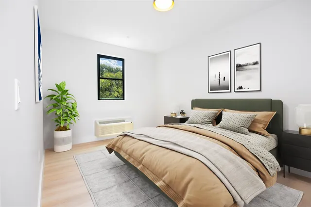 a bedroom with a large bed and a potted plant
