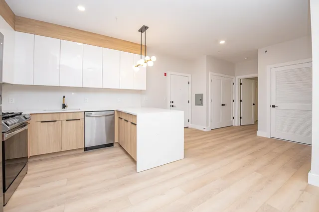 a kitchen with white cabinets and white appliances