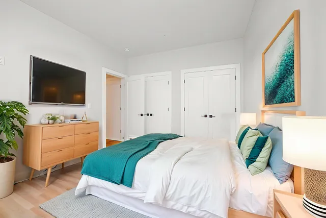 a bedroom with a bed and a flat screen tv