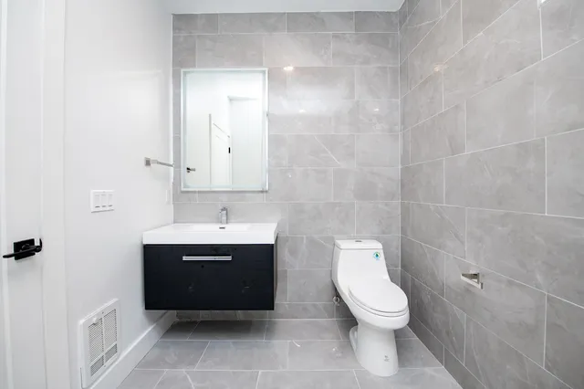 a bathroom with a toilet sink and mirror