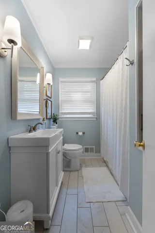 a bathroom with a sink a toilet and mirror