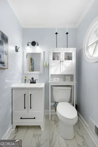 a bathroom with a toilet a sink and mirror