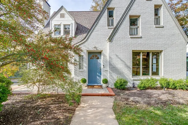 a front view of a house with a yard and potted plants