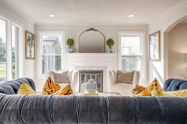 a living room with furniture a fireplace and a large window