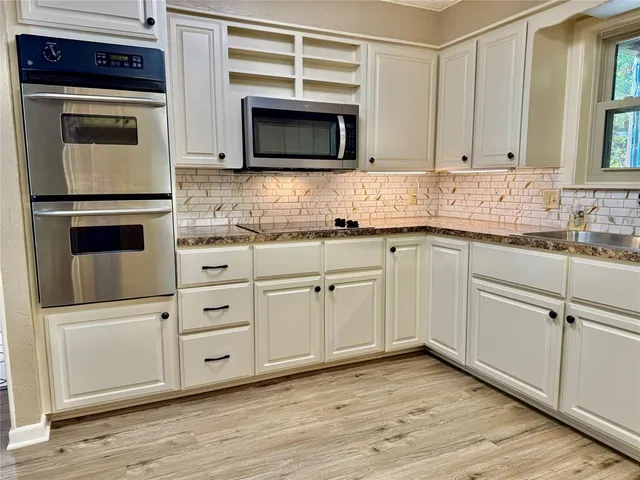 a kitchen with white cabinets stainless steel appliances and sink