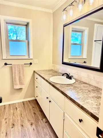 a bathroom with a granite countertop sink and a window