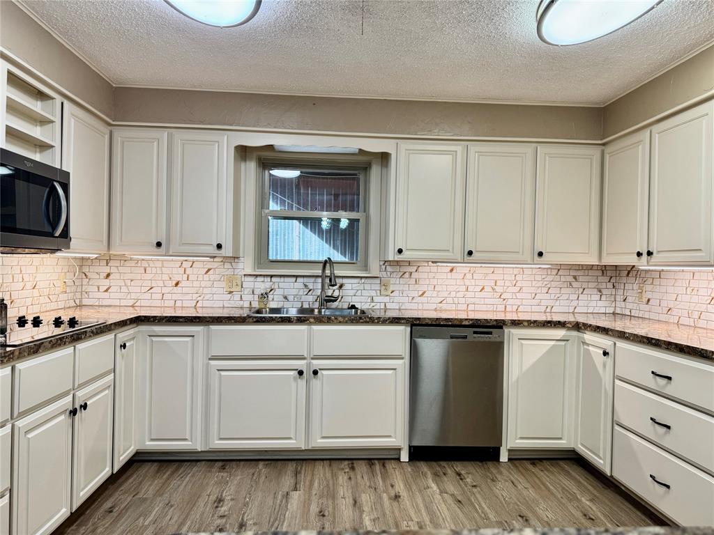 604 North 19th Street Haskell, TX 79521 - Photo 19 of 36 a kitchen with sink cabinets and wooden floor