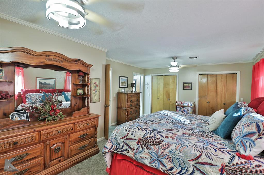 604 North 19th Street Haskell, TX 79521 - Photo 21 of 36 a bedroom with a bed and a chandelier