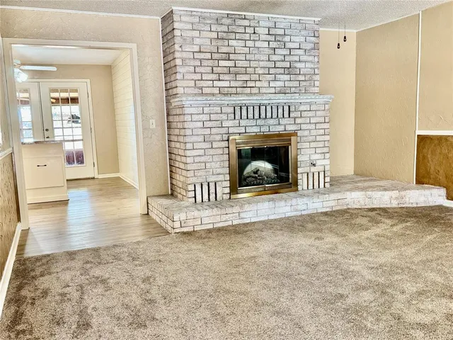 a view of a livingroom with wooden floor and a fireplace