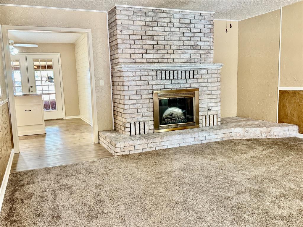 604 North 19th Street Haskell, TX 79521 - Photo 9 of 36 a view of a livingroom with wooden floor and a fireplace