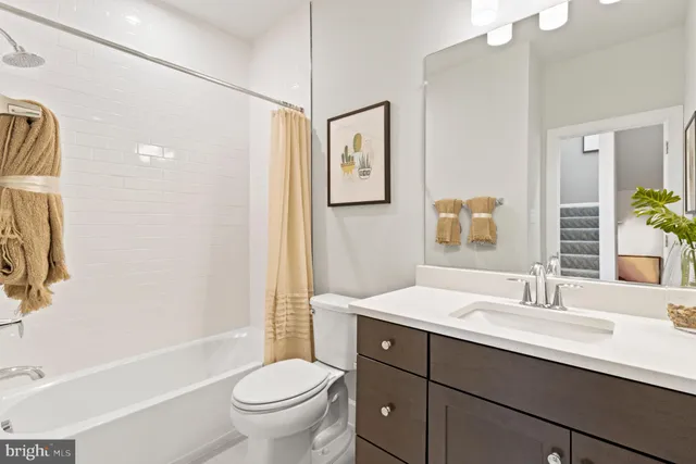 a bathroom with a toilet a sink a mirror a bathtub and shower