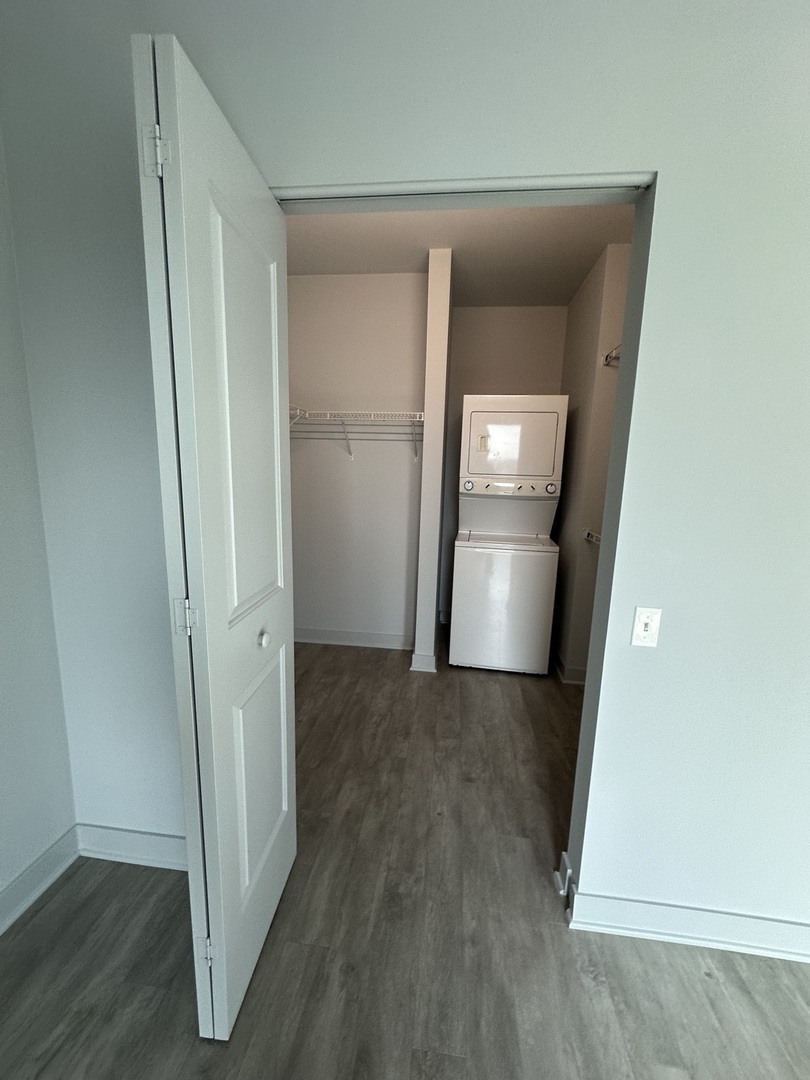 1025 West Addison Street, Unit 706 Chicago, IL 60613 - Photo 11 of 25 an empty room with wooden floor and a kitchen