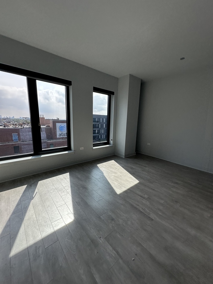 1025 West Addison Street, Unit 706 Chicago, IL 60613 - Photo 15 of 25 an empty room with large windows and city view