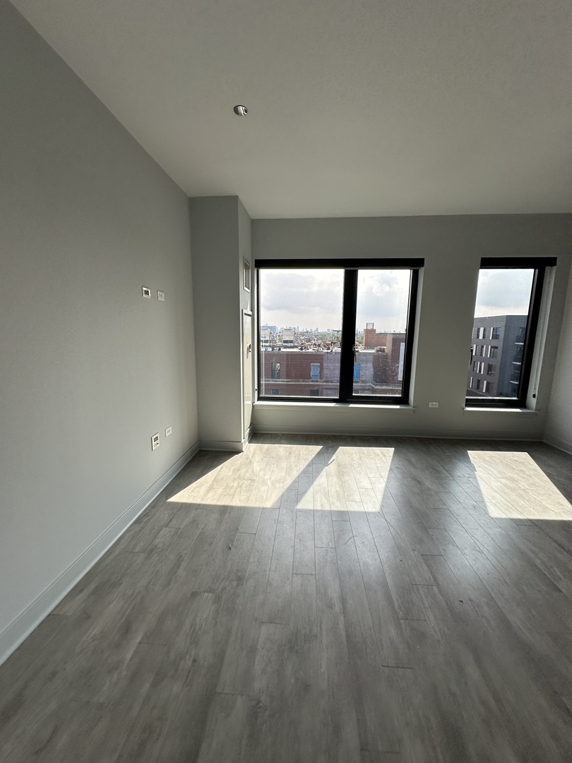 1025 West Addison Street, Unit 706 Chicago, IL 60613 - Photo 16 of 25 an empty room with wooden floor and windows
