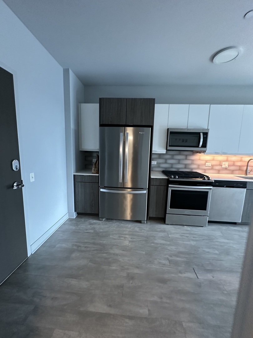 1025 West Addison Street, Unit 706 Chicago, IL 60613 - Photo 20 of 25 a kitchen with granite countertop a refrigerator and a stove
