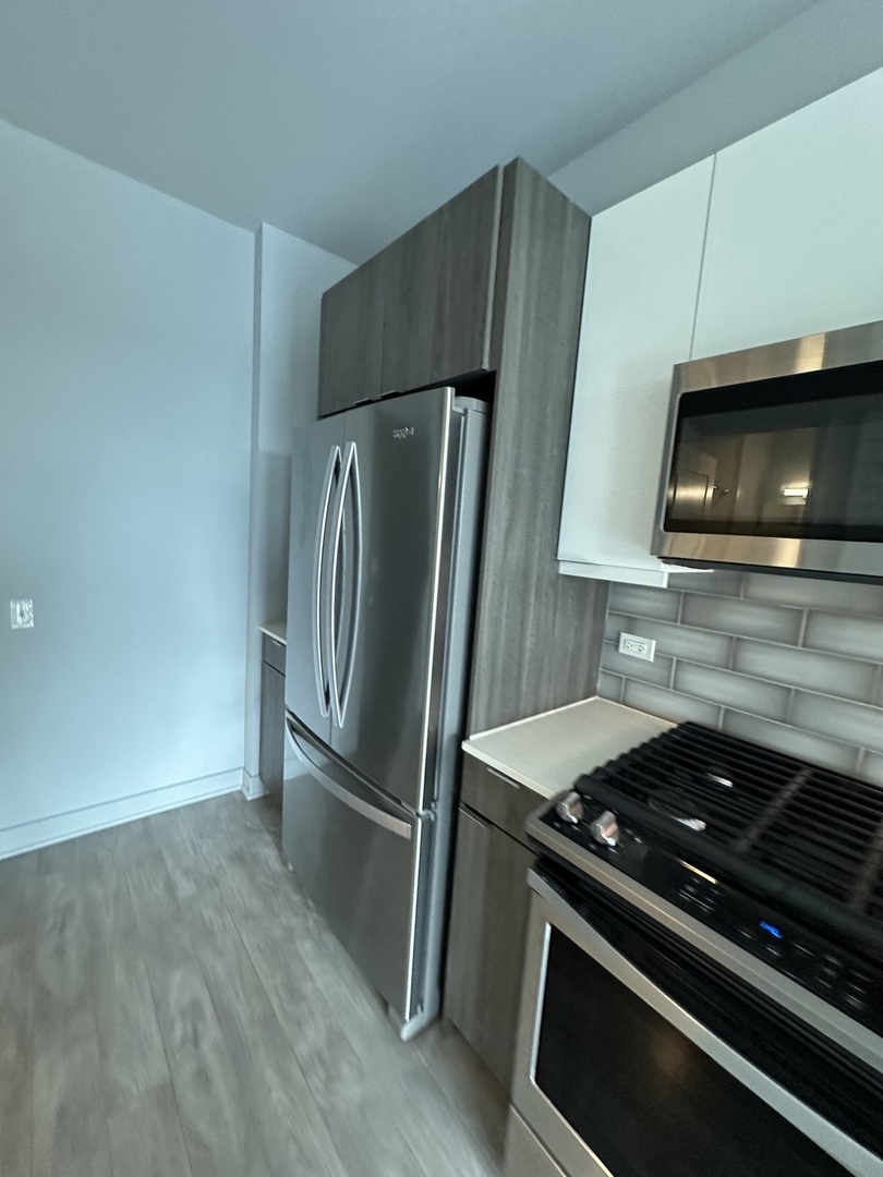 1025 West Addison Street, Unit 706 Chicago, IL 60613 - Photo 2 of 25 a kitchen with a stove microwave and refrigerator