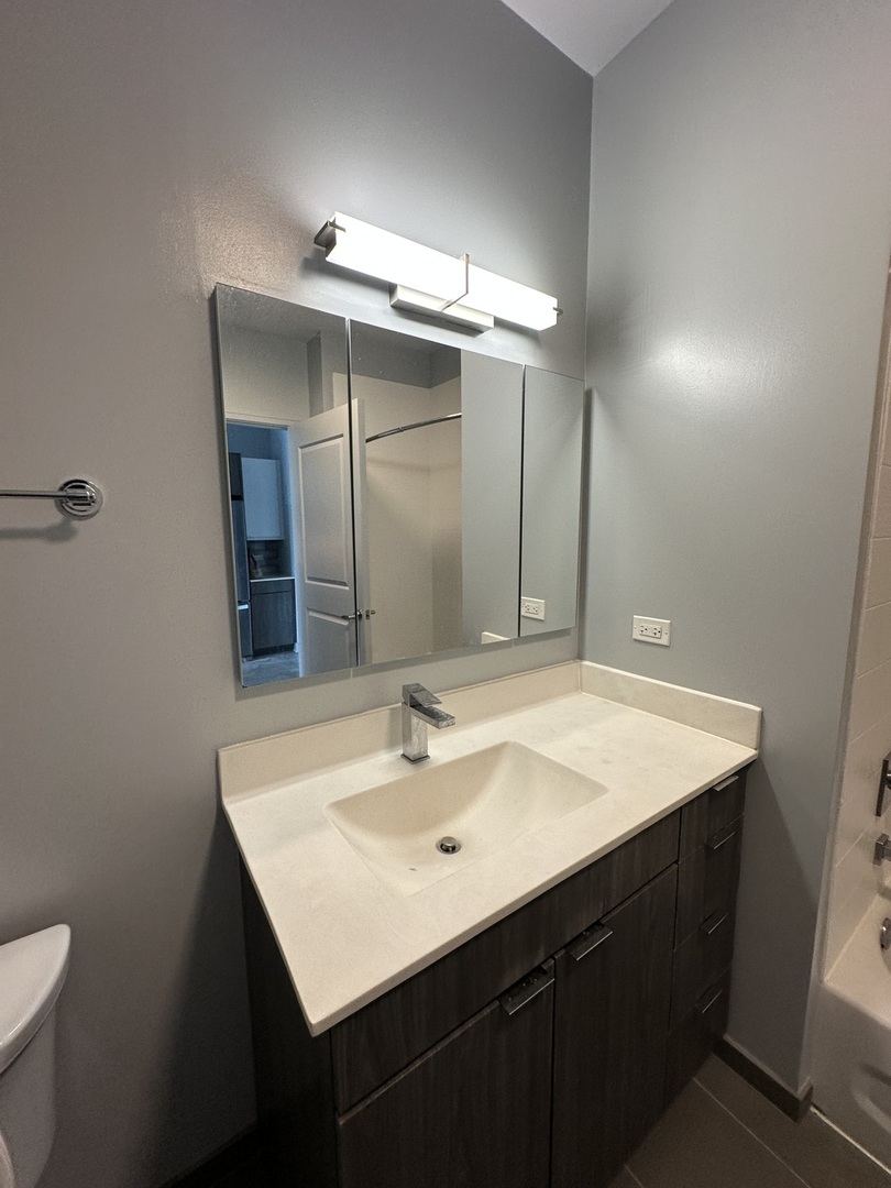 1025 West Addison Street, Unit 706 Chicago, IL 60613 - Photo 21 of 25 a bathroom with a sink vanity and a mirror
