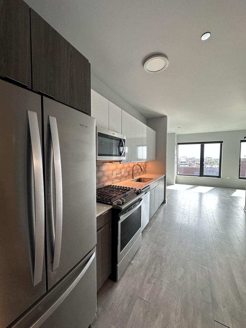 1025 West Addison Street, Unit 706 Chicago, IL 60613 - Photo 25 of 25 a large kitchen with stainless steel appliances a refrigerator and a stove