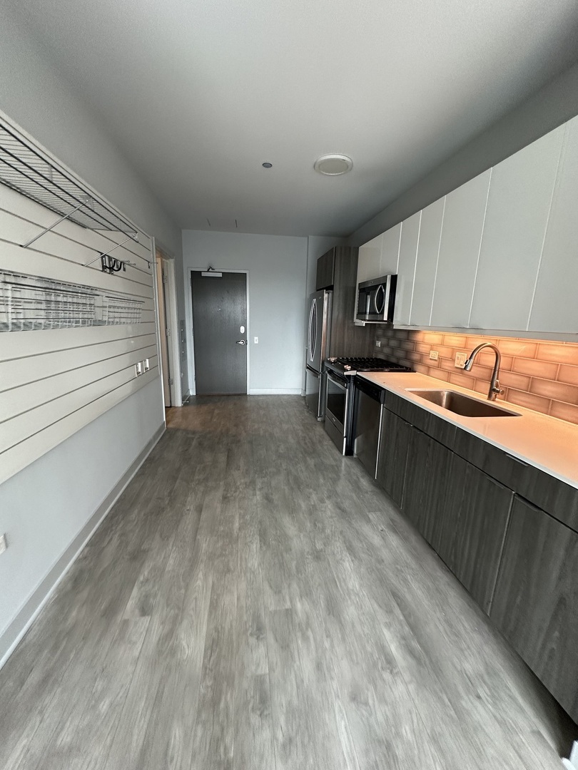 1025 West Addison Street, Unit 706 Chicago, IL 60613 - Photo 4 of 25 a view of a kitchen with a sink and dishwasher