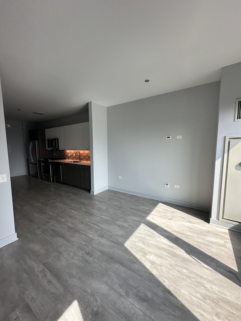 1025 West Addison Street, Unit 706 Chicago, IL 60613 - Photo 7 of 25 a view of empty room with furniture and wooden floor