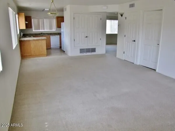 a view of a kitchen with white cabinets and stainless steel appliances