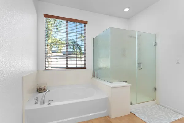 a bedroom with a bed and a dresser next to a window