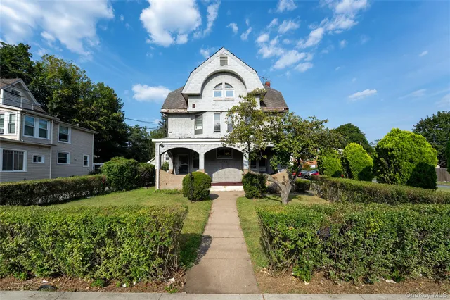 a front view of a house with a garden