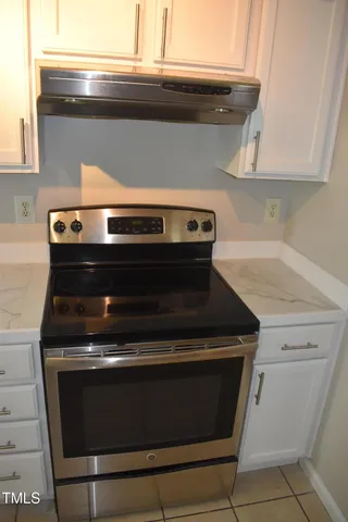 a stove top oven sitting inside of a kitchen