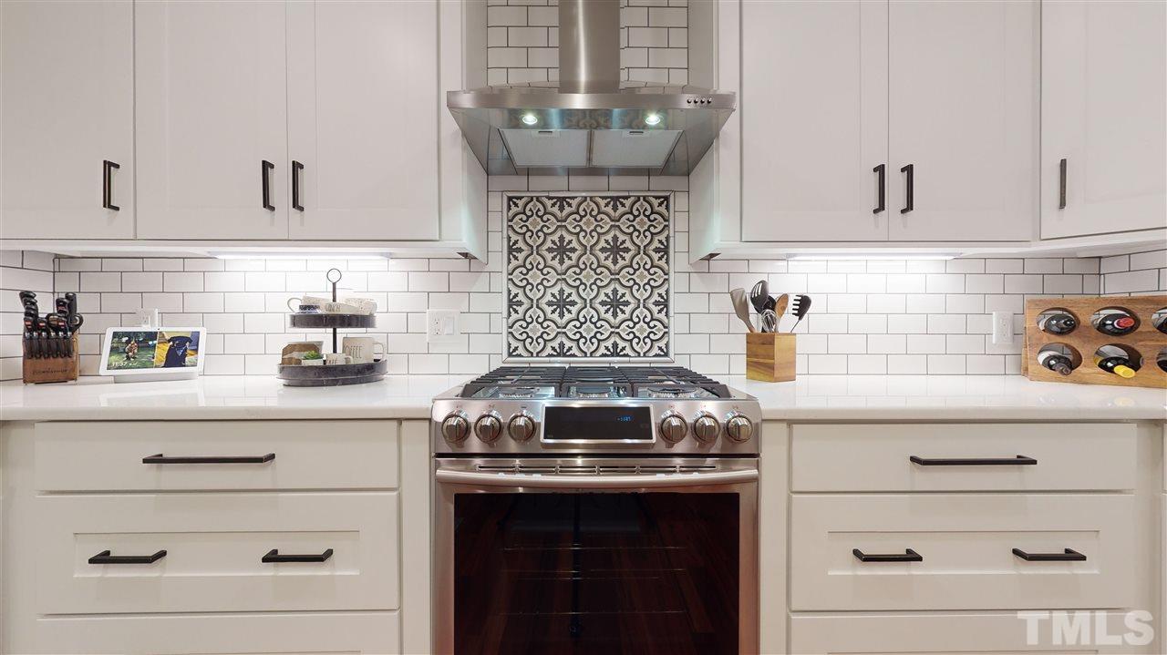 6105 Ivy Ridge Road Raleigh, NC 27612 - Photo 12 of 27 a kitchen with a stove cabinets and window