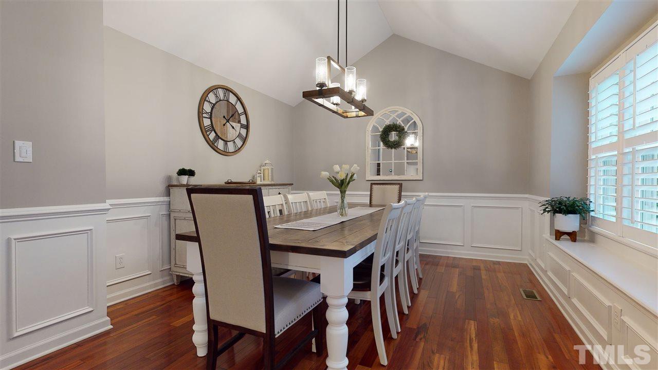6105 Ivy Ridge Road Raleigh, NC 27612 - Photo 15 of 27 a view of a dining room with furniture a chandelier and wooden floor