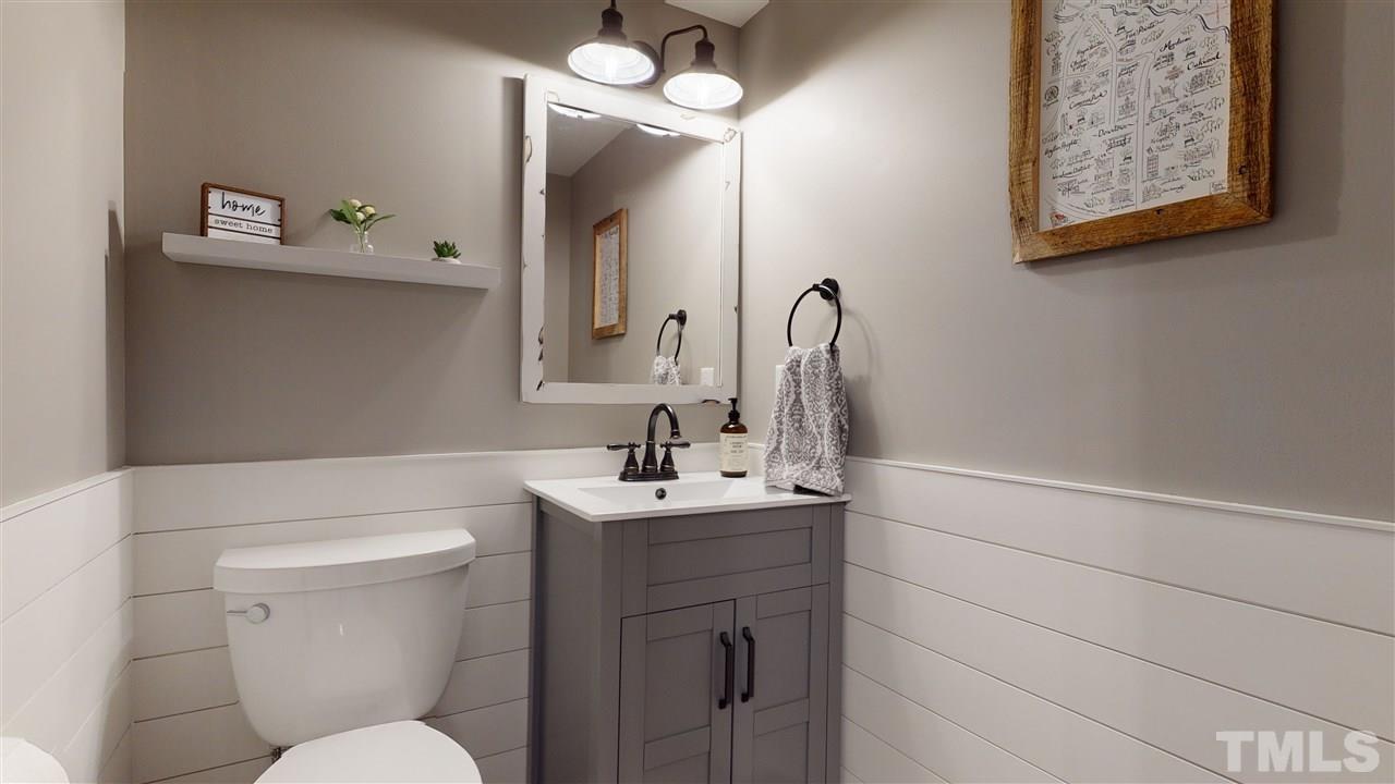 6105 Ivy Ridge Road Raleigh, NC 27612 - Photo 16 of 27 a bathroom with a toilet a sink and mirror