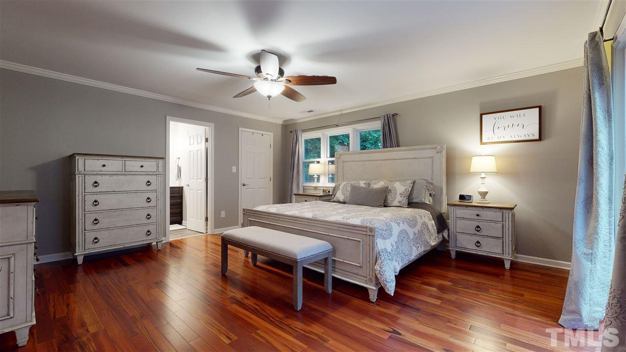 6105 Ivy Ridge Road Raleigh, NC 27612 - Photo 18 of 27 a bedroom with a bed and wooden floor