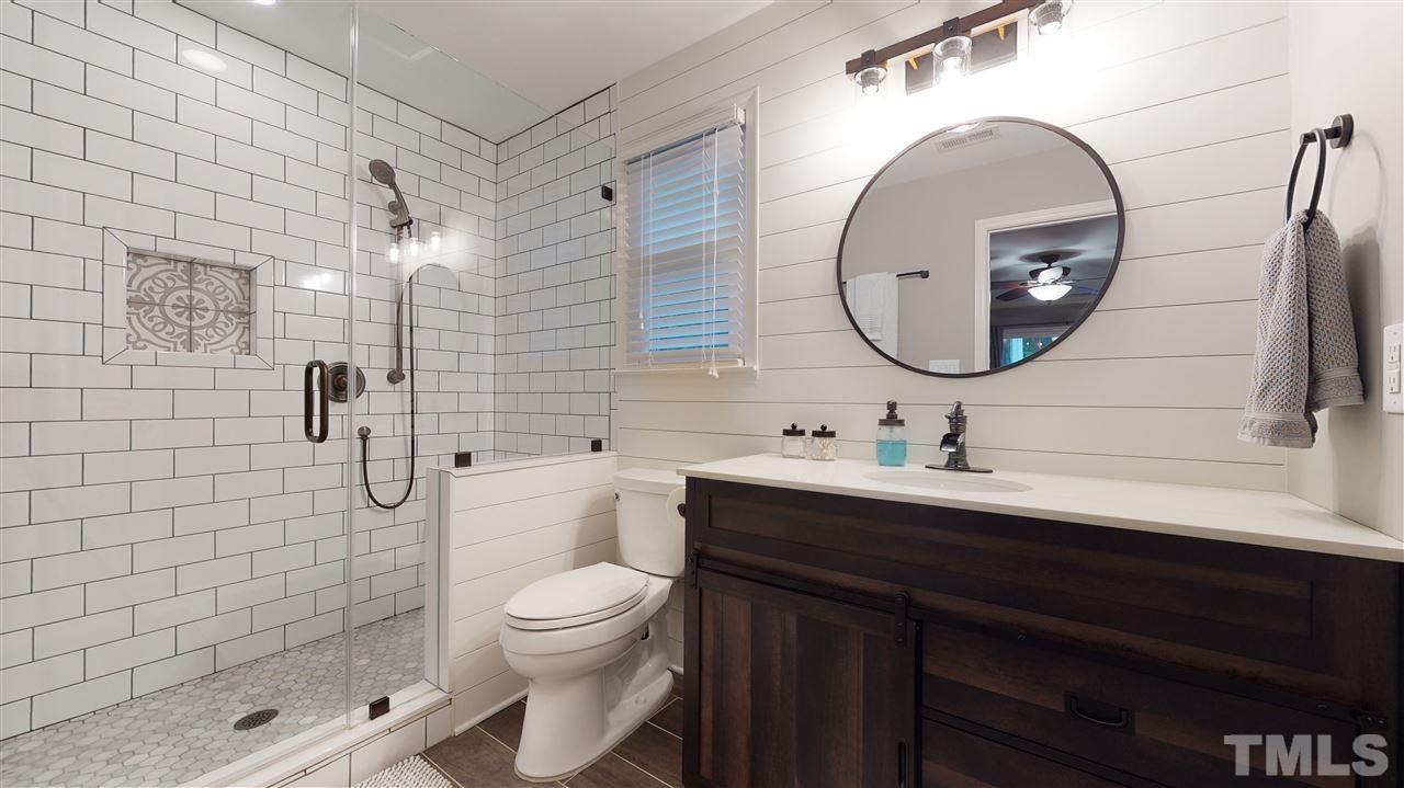 6105 Ivy Ridge Road Raleigh, NC 27612 - Photo 19 of 27 a bathroom with a sink a toilet and a mirror