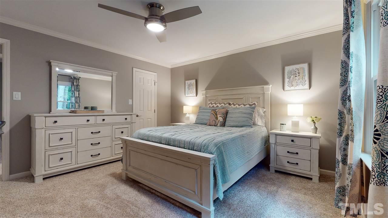 6105 Ivy Ridge Road Raleigh, NC 27612 - Photo 20 of 27 a spacious bedroom with a bed and a dresser