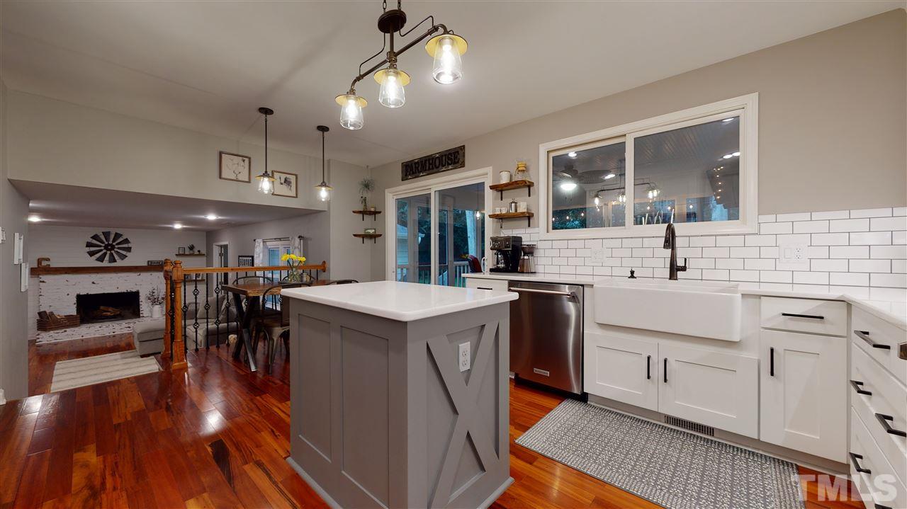 6105 Ivy Ridge Road Raleigh, NC 27612 - Photo 10 of 27 a kitchen with a sink a counter top space stainless steel appliances and wooden floor