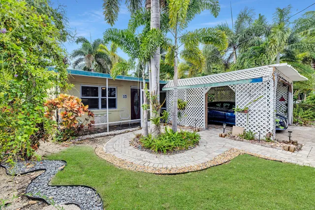 a view of a house with a small yard and potted plants