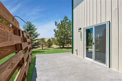a view of a house with backyard and trees