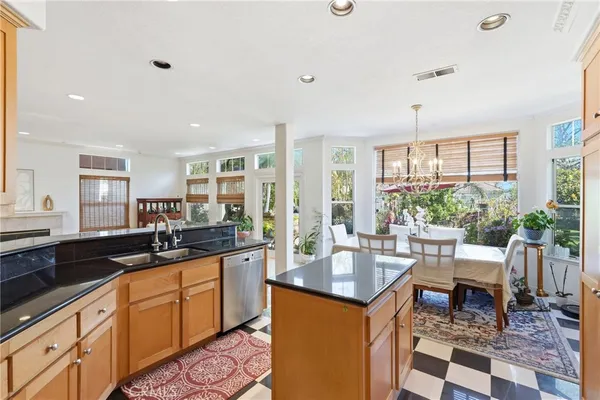 a kitchen with granite countertop a sink and white cabinets