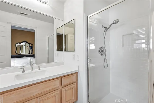 a bathroom with a double vanity sink mirror and shower