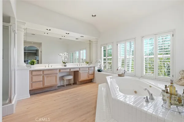 a large white bathroom with a large tub a sink and a large window