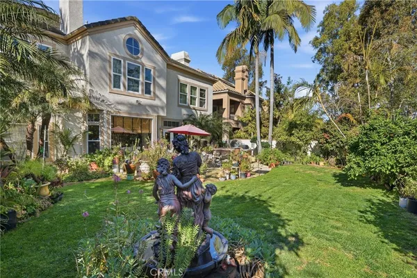 a backyard of a house with a garden and outdoor seating