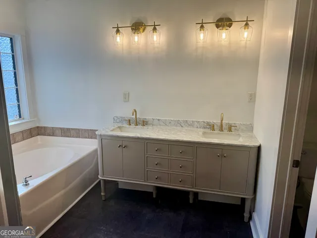 a bathroom with double vanity and a bathtub