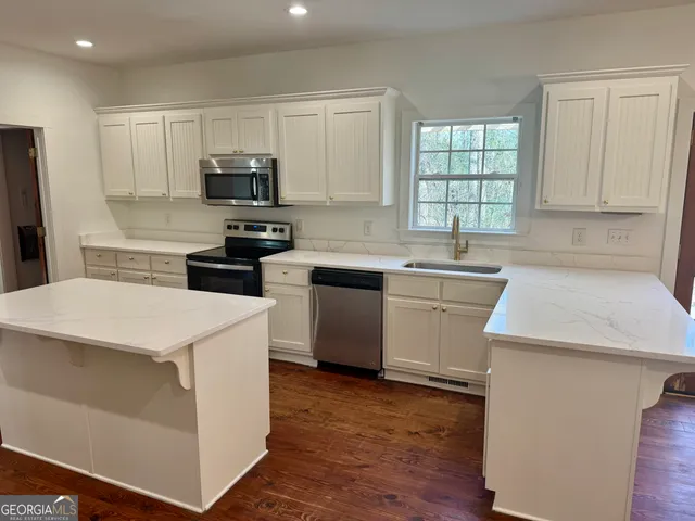 a kitchen with stainless steel appliances white cabinets and sink