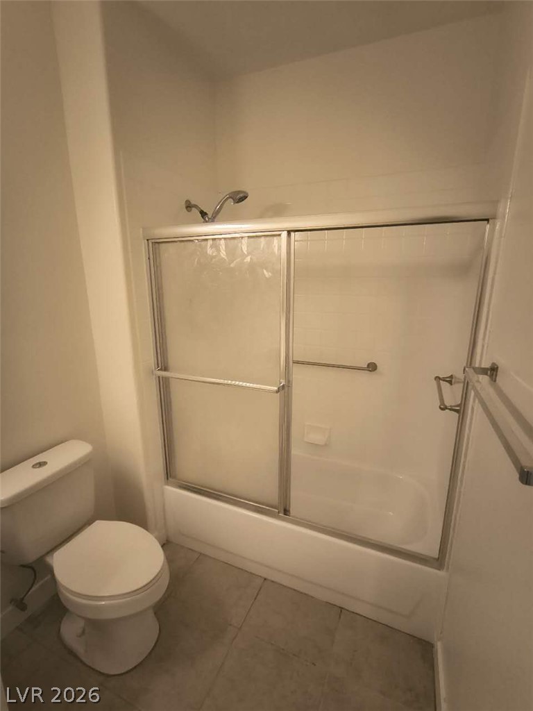 9725 Pima Point Avenue Las Vegas, NV 89147 - Photo 26 of 35 A well-maintained bathroom with a combination tub and shower, featuring practical sliding glass doors and tiled flooring.