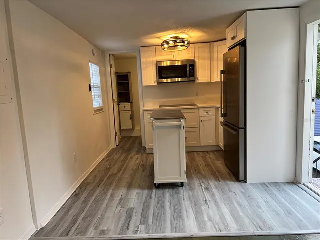 a kitchen with a refrigerator and a stove top oven