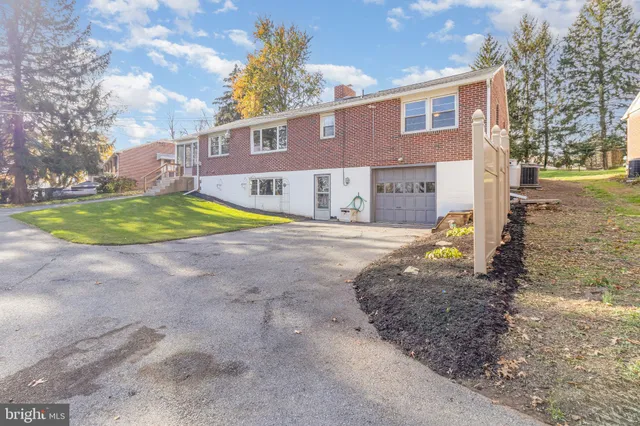 a view of a house with a yard and large tree